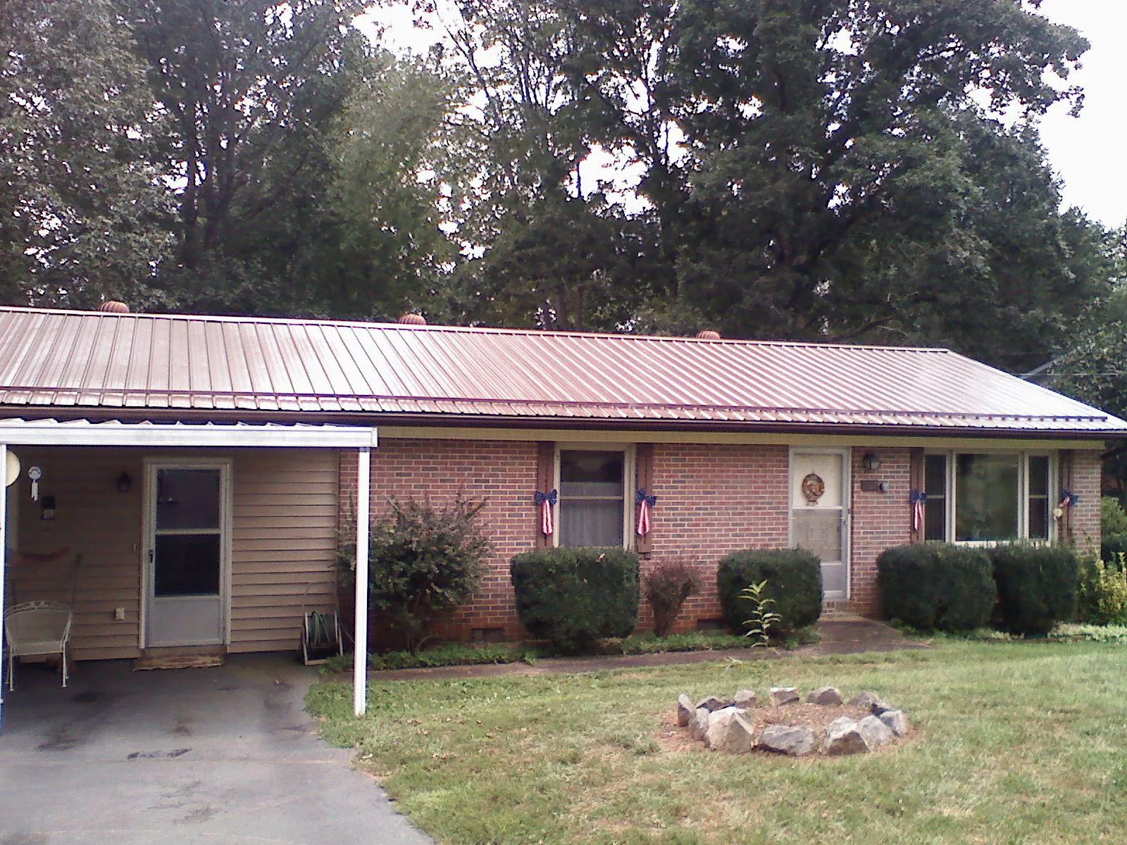 Bronze metal roof and carport on a brick ranch home — Roof Repair work by our crew in Greenwood